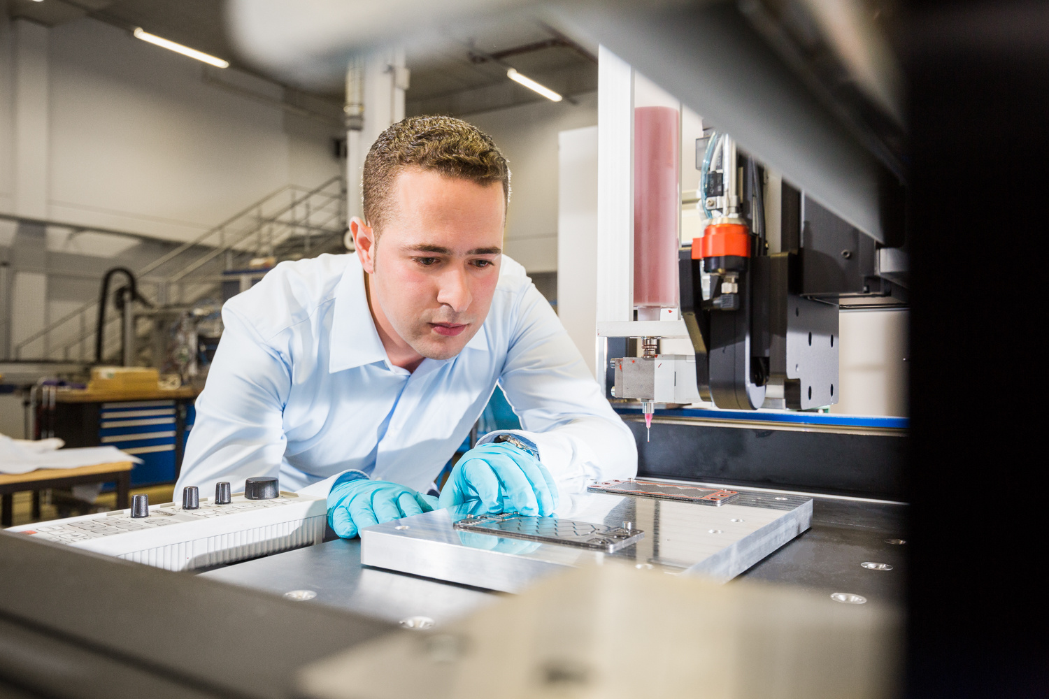 Wissenschaftler beugt sich über ein Gerät zur Aufbringung von Dichtungen auf Bipolarplatten