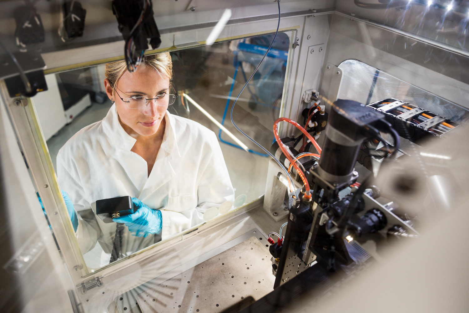 Wissenschaftlerin durch einen Teststand hindurch fotografiert
