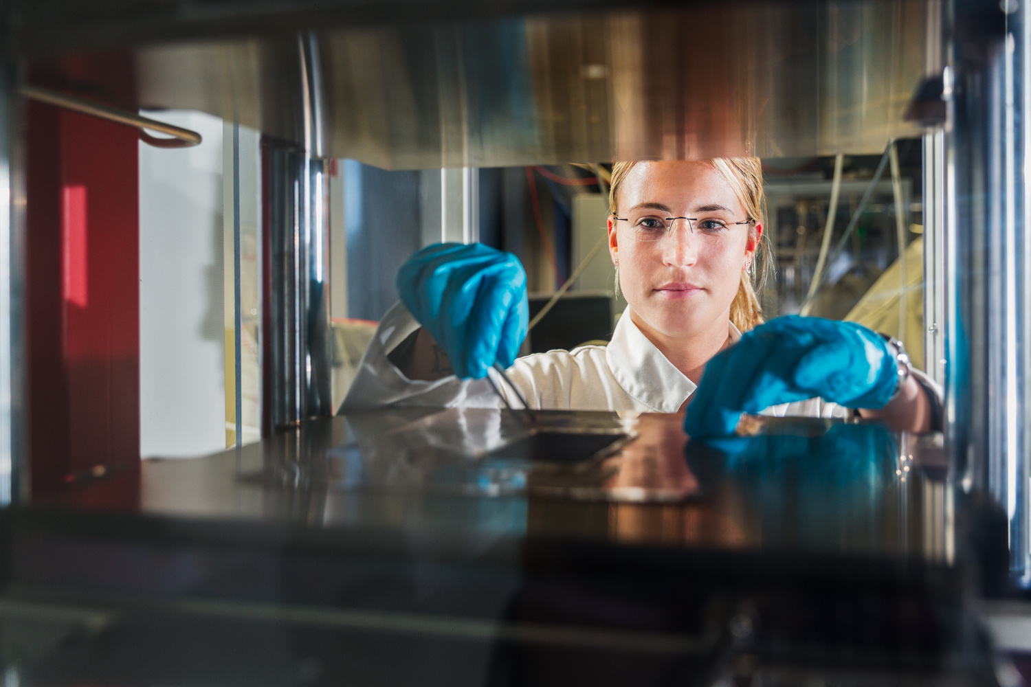 Wissenschaftlerin durch einen Teststand hindurch fotografiert