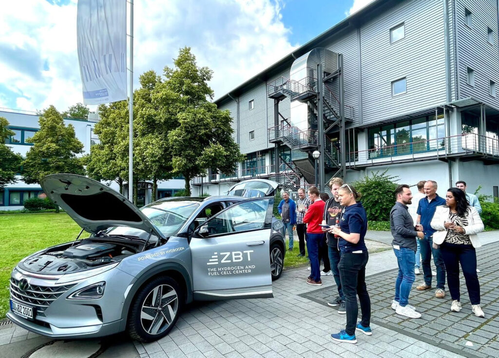 Personen stehen um das brennstoffzellenelektrische Dienstfahrzeug des ZBT - Zentrum für BrennstoffzellenTechnik herum