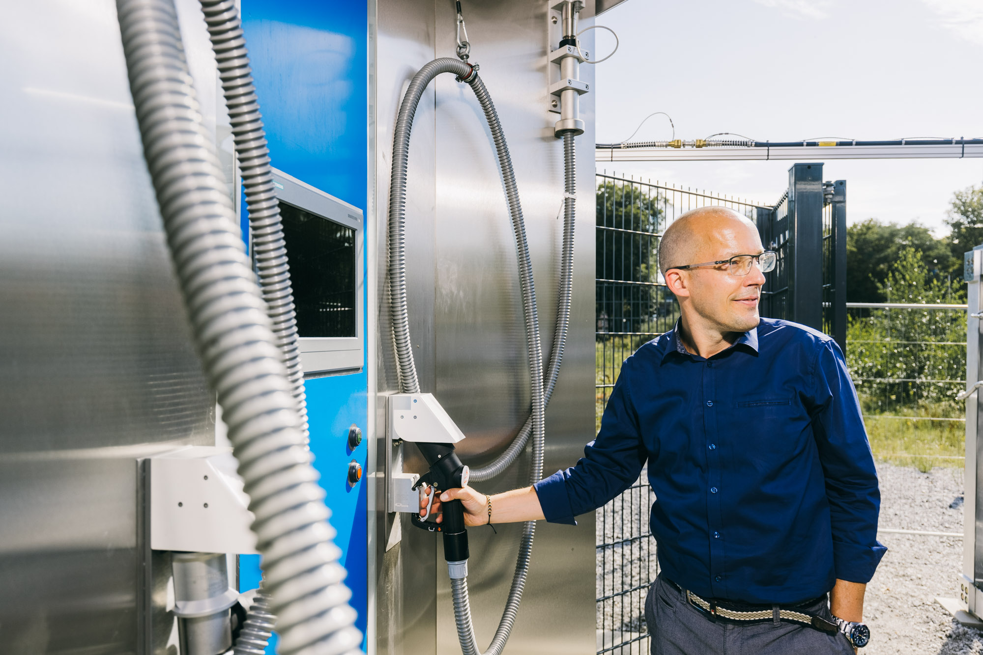 A ZBT employee reaches for the fuel nozzle at the ZBT hydrogen filling station
