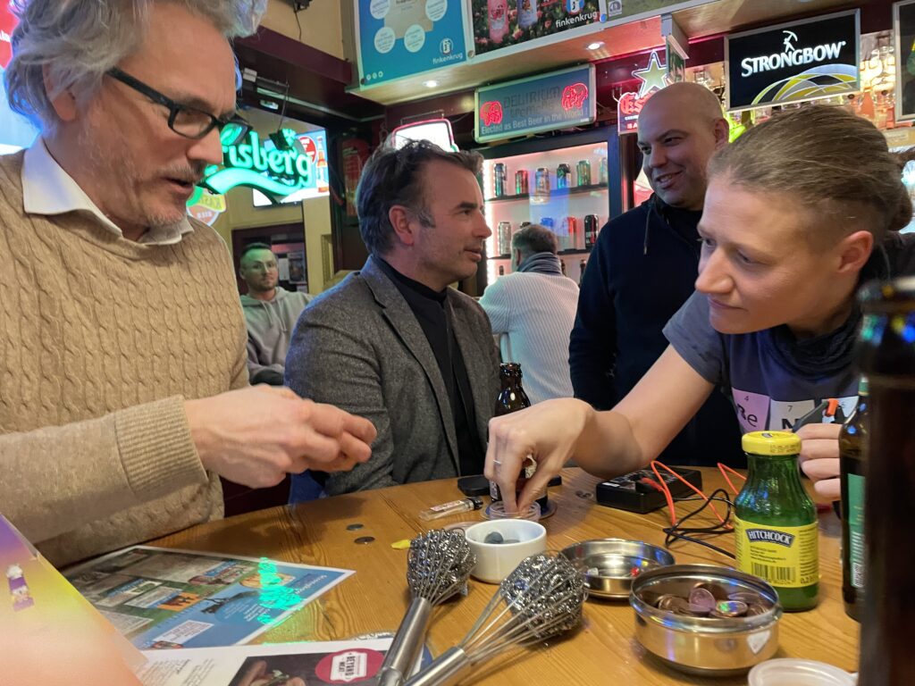 Prof. Harry Hoster und Dr. Theresa Schredelseker experimentieren beim Wasserstoffstammtisch in einer Kneipe.