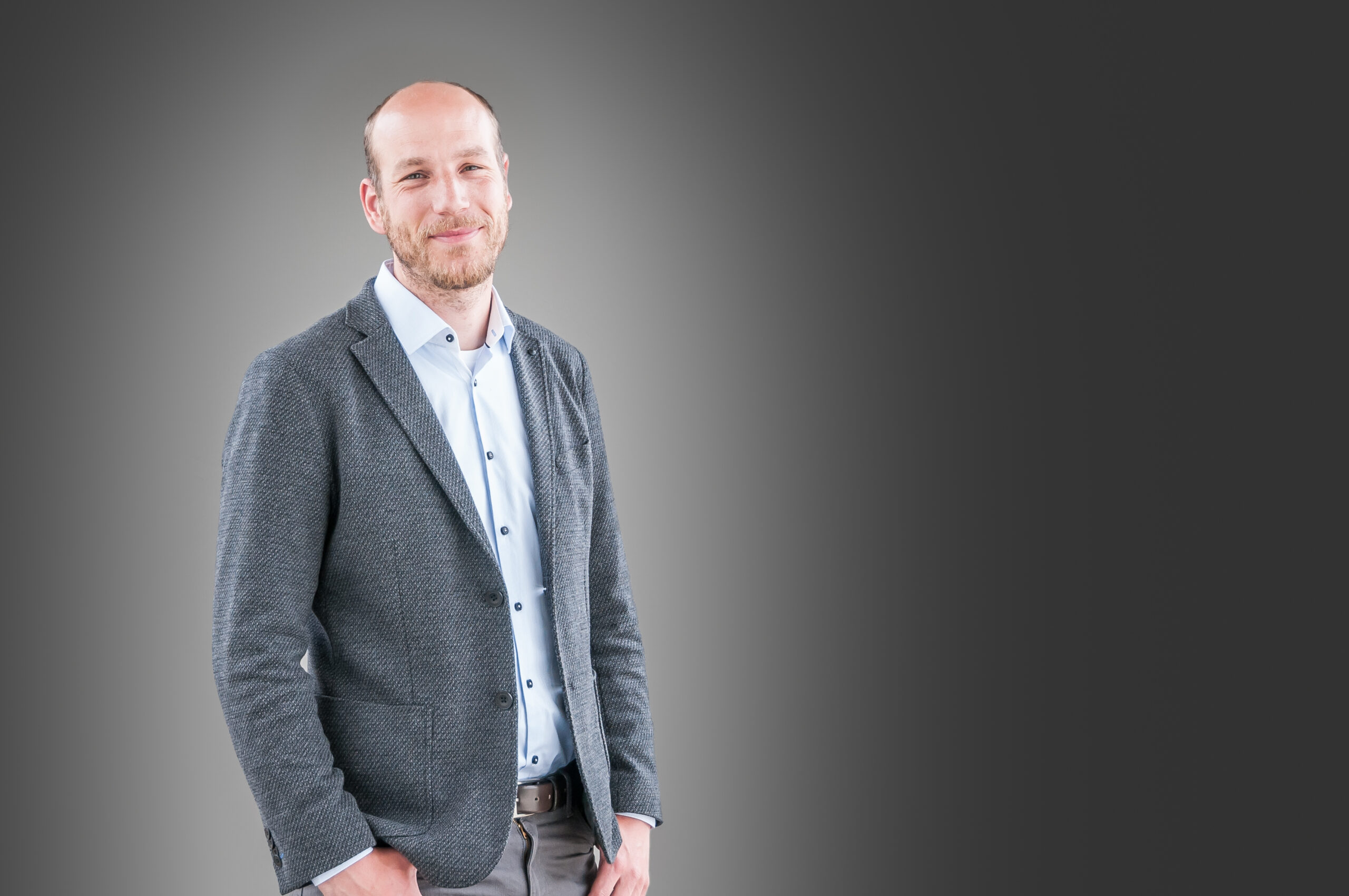 Business-Portrait eines Manns mit Jacket, Hemd und Jeans