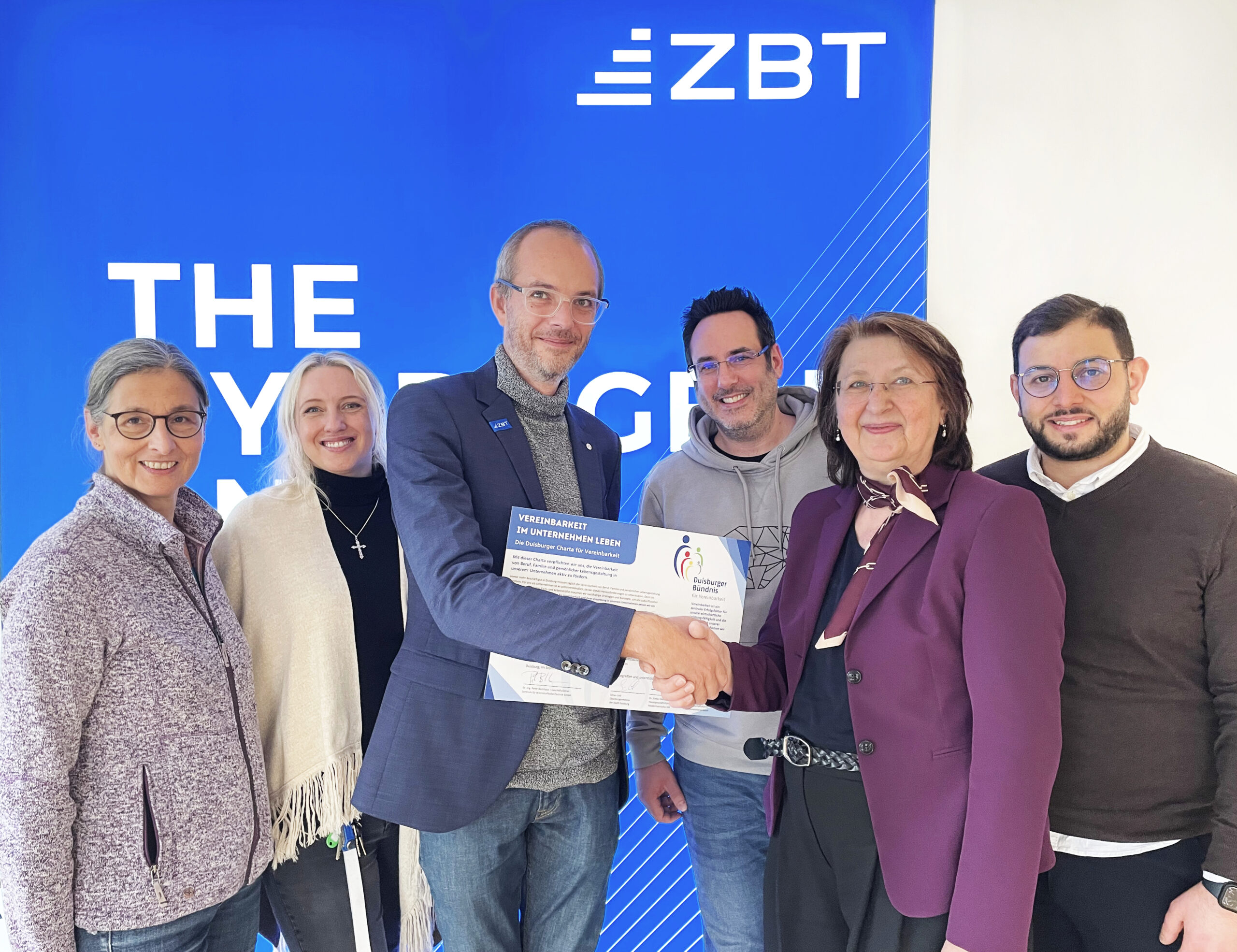 Gruppenfoto mit sechs Personen bei der Überreichung einer Urkunde